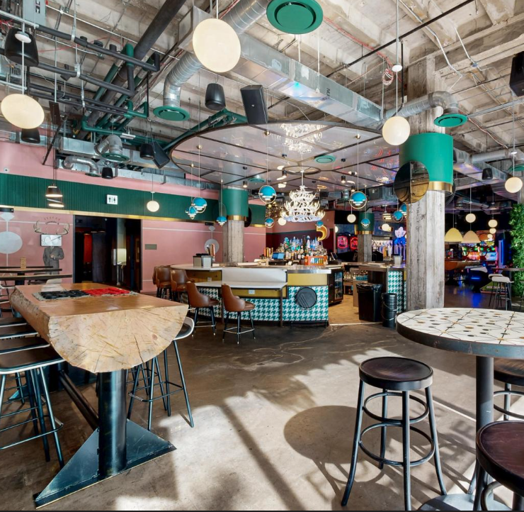 Coworkers bowling and playing arcade games during a social team building event in Austin